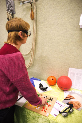 Eine Lehrkraft experimentiert mit einer Brille, die ein stark eingeschränktes Sichtfeld simuliert